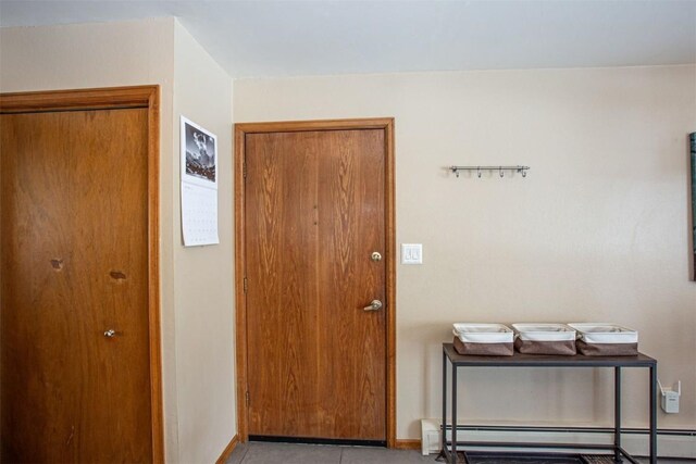 foyer with a baseboard heating unit and baseboards