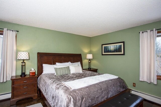 bedroom featuring a baseboard radiator, baseboards, and a textured ceiling