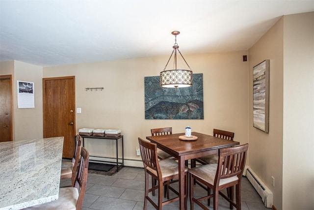 dining room with a baseboard heating unit and tile patterned floors