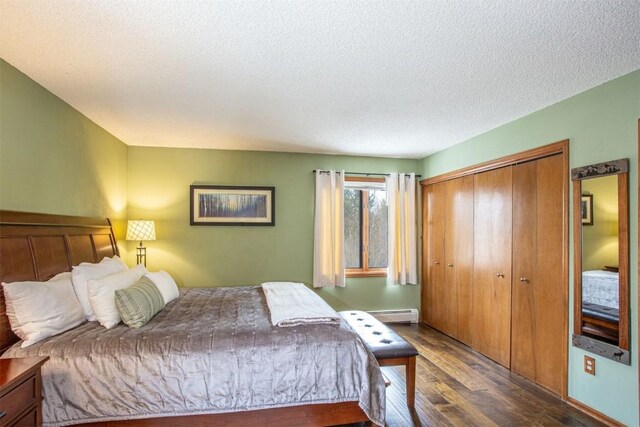 bedroom featuring a baseboard radiator, a closet, wood finished floors, and a textured ceiling