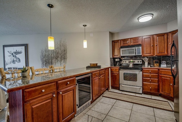 kitchen featuring tile countertops, a textured ceiling, beverage cooler, a peninsula, and stainless steel appliances