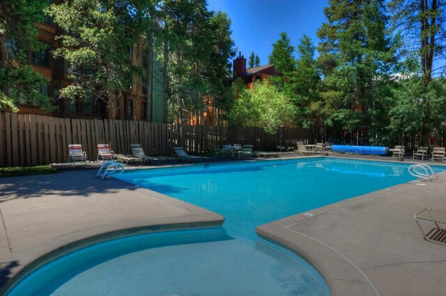 pool featuring fence and a patio