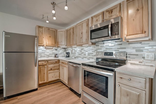 1133 Straight Creek Dr Unit 108, Dillon, CO 80435 - kitchen with stainless steel appliances, light brown cabinetry, light wood-style flooring, and decorative backsplash