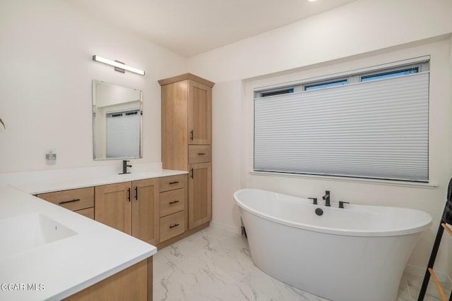 bathroom with a freestanding tub, marble finish floor, and vanity