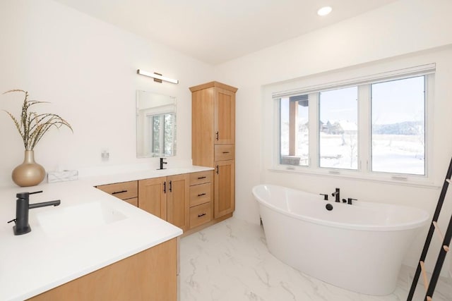 bathroom with a soaking tub, marble finish floor, recessed lighting, and vanity