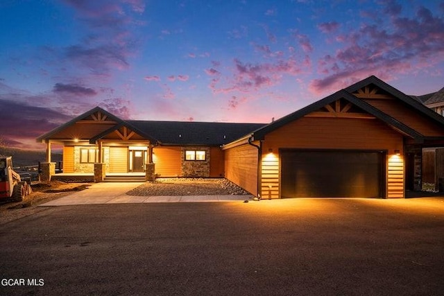 view of front of home with an attached garage, driveway, and a porch
