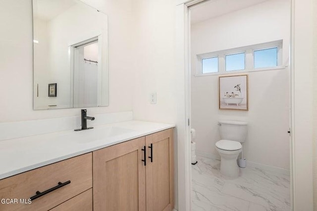 full bathroom with vanity, marble finish floor, baseboards, and toilet