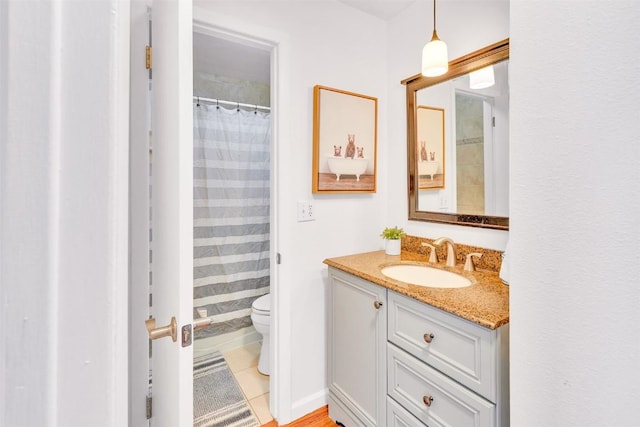 bathroom with toilet, tile patterned floors, curtained shower, and vanity