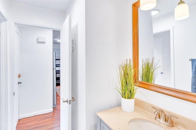 bathroom with vanity, baseboards, and wood finished floors