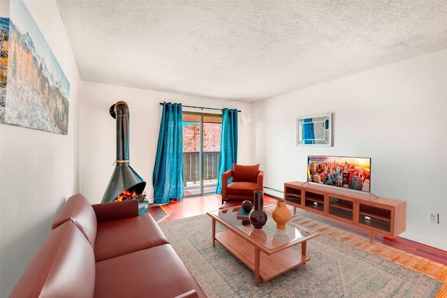 living area with a baseboard radiator, a textured ceiling, and wood finished floors