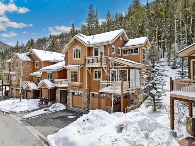 129 Tip Top Trl Unit 6543, Keystone, CO 80435 - snow covered property with stone siding, aphalt driveway, and a garage