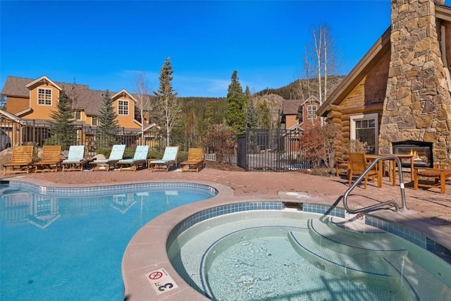 129 Tip Top Trl Unit 6543, Keystone, CO 80435 - community pool featuring fence, an outdoor stone fireplace, a hot tub, and a patio