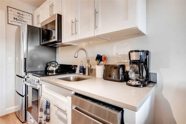 3295 Apres Ski Way Unit B10, Steamboat Springs, CO 80487 - kitchen with appliances with stainless steel finishes, white cabinets, and light countertops