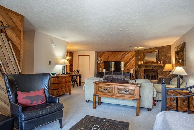 carpeted living area featuring a fireplace, wood walls, and a textured ceiling