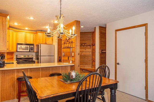 dining space featuring light carpet, a textured ceiling, recessed lighting, and a notable chandelier
