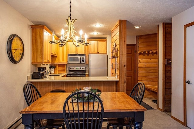 dining room with a baseboard heating unit, an inviting chandelier, carpet flooring, and baseboards