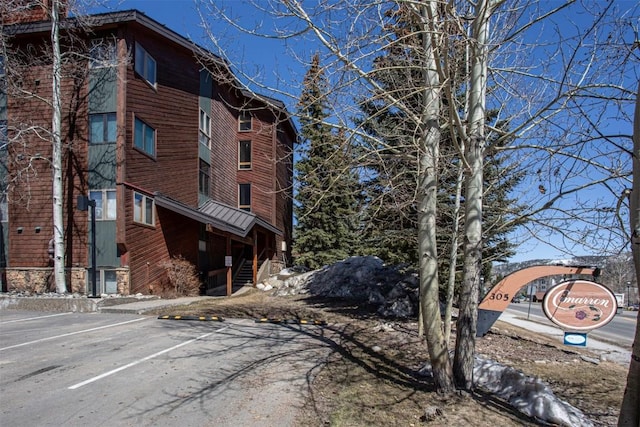 view of property featuring stairs and uncovered parking