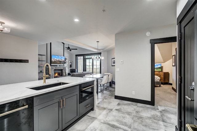 1891 Ski Hill Rd Unit 7404, Breckenridge, CO 80424 - kitchen featuring a sink, dishwasher, a stone fireplace, ceiling fan with notable chandelier, and baseboards