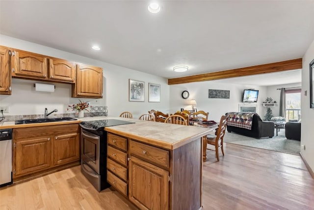 9460 Ryan Gulch Rd Unit 65, Silverthorne, CO 80498 - kitchen featuring light wood-type flooring, a peninsula, appliances with stainless steel finishes, and a sink