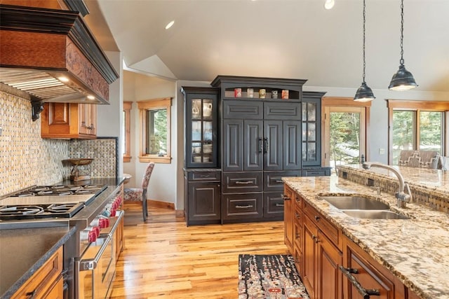 174 Sage Dr, Breckenridge, CO 80424 - kitchen featuring a sink, light wood-style floors, range with two ovens, decorative backsplash, and custom range hood