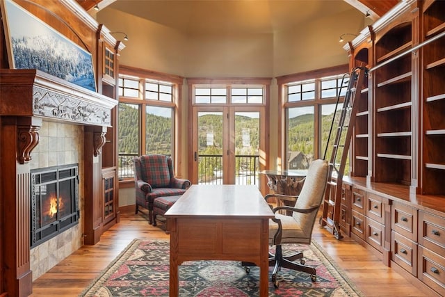 174 Sage Dr, Breckenridge, CO 80424 - home office featuring light wood-style floors, a mountain view, a towering ceiling, and a tile fireplace