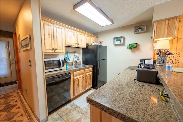 kitchen featuring light brown cabinetry, tile countertops, a sink, black appliances, and a textured ceiling