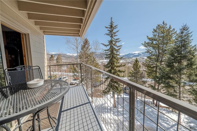 snow covered back of property with a mountain view
