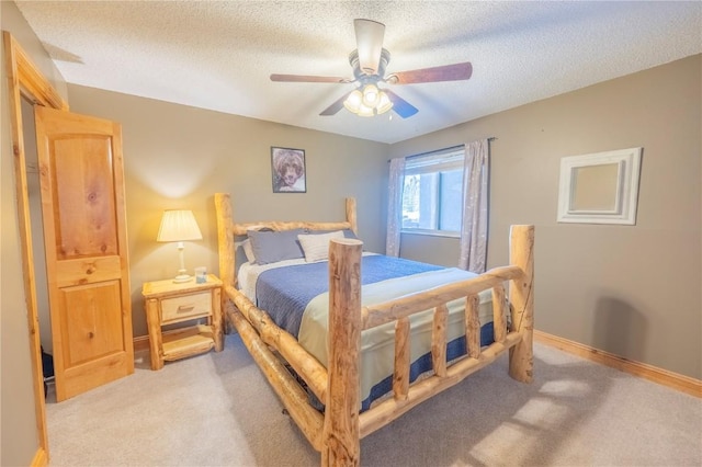 bedroom with baseboards, a textured ceiling, a ceiling fan, and light colored carpet