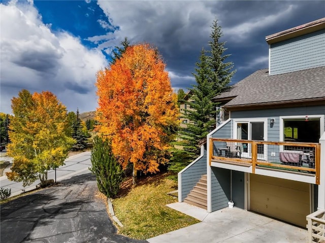 111 Corinthian Cir Unit A, Dillon, CO 80435 - view of side of property with stairway, a garage, roof with shingles, and concrete driveway