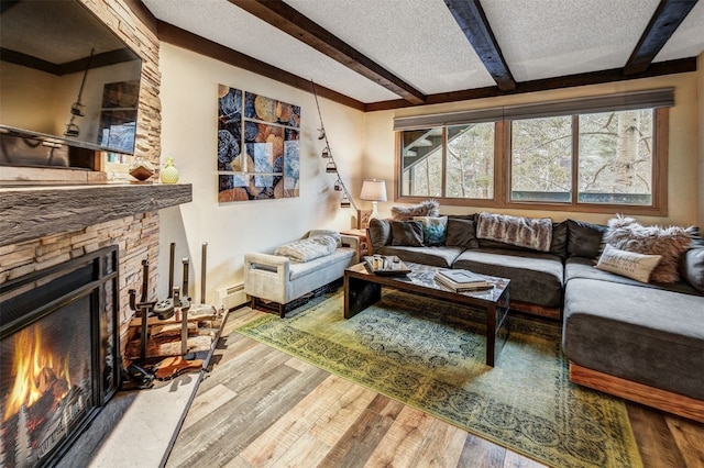 311 S High St Unit 108, Breckenridge, CO 80424 - living room with beam ceiling, wood finished floors, a textured ceiling, a baseboard heating unit, and a fireplace
