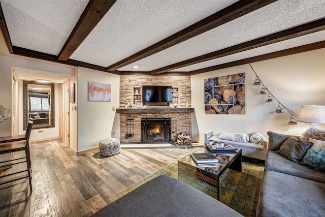311 S High St Unit 108, Breckenridge, CO 80424 - living area with a fireplace, beam ceiling, hardwood / wood-style floors, baseboards, and a textured ceiling