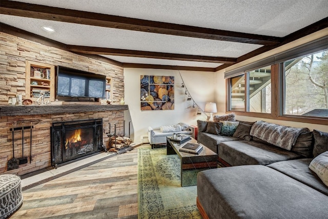 311 S High St Unit 108, Breckenridge, CO 80424 - living area with a textured ceiling, wood finished floors, beam ceiling, a fireplace, and a baseboard radiator
