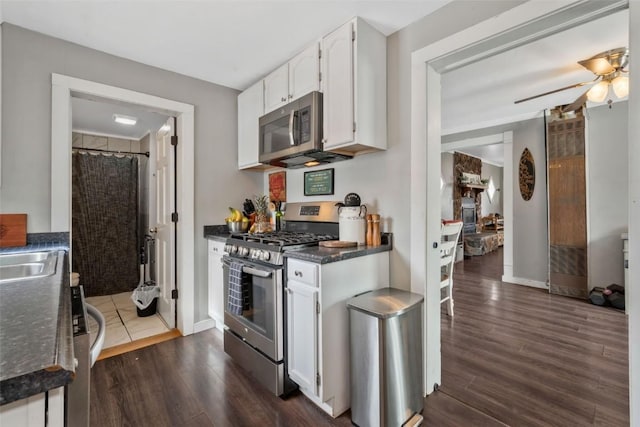 609 E Jefferson Ave, Hayden, CO 81639 - kitchen with stainless steel appliances, dark countertops, white cabinets, dark wood-type flooring, and a ceiling fan
