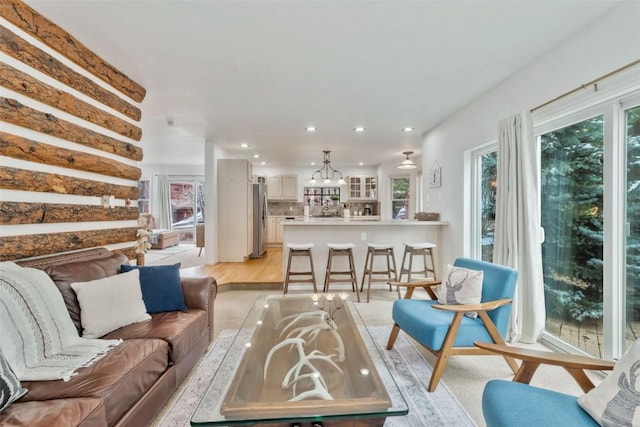 living room with recessed lighting, light wood-style flooring, and a notable chandelier