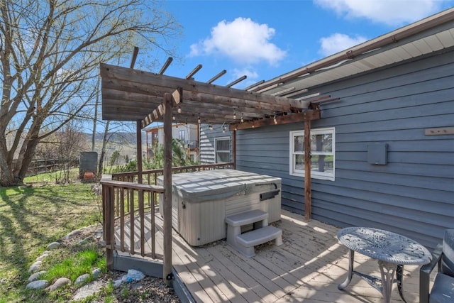 deck featuring a hot tub and a pergola