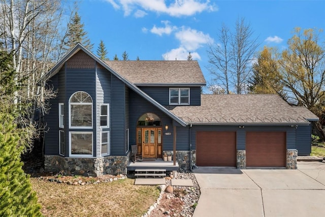 view of front of property with a shingled roof, an attached garage, concrete driveway, and stone siding