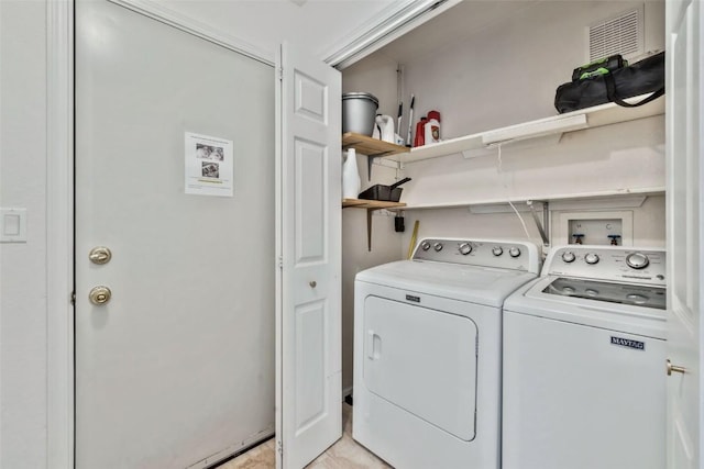 washroom featuring washer and dryer, laundry area, and visible vents