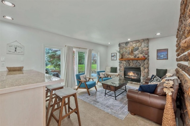 living area featuring a fireplace, recessed lighting, and light carpet