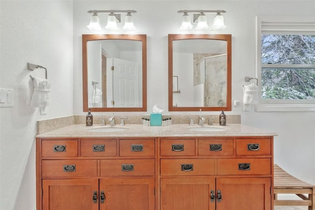 bathroom with double vanity, a shower stall, and a sink