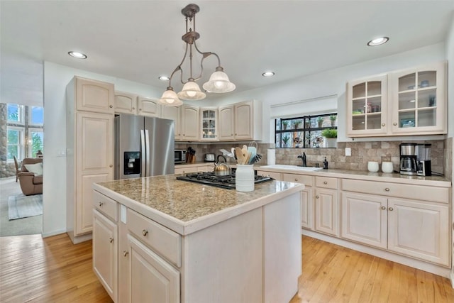 kitchen with a center island, a sink, decorative backsplash, and appliances with stainless steel finishes