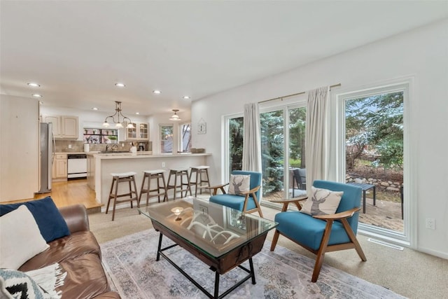 living area with recessed lighting, an inviting chandelier, a healthy amount of sunlight, and visible vents