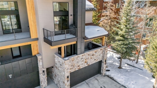 view of side of home with stone siding and a balcony