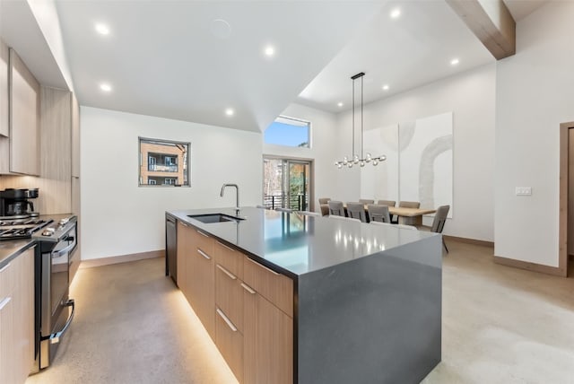 kitchen featuring modern cabinets, appliances with stainless steel finishes, a sink, and a center island with sink