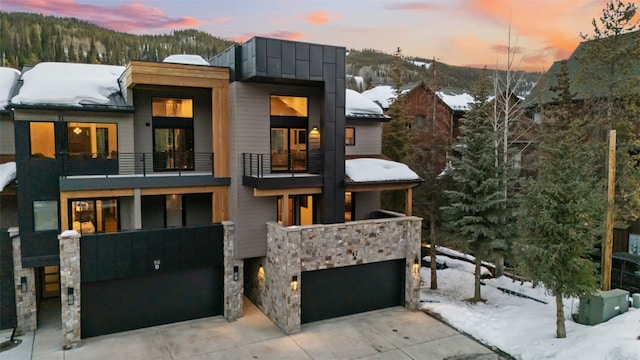 96 River Run Rd Unit A, Keystone, CO 80435 - contemporary house with driveway, stone siding, a balcony, and a garage