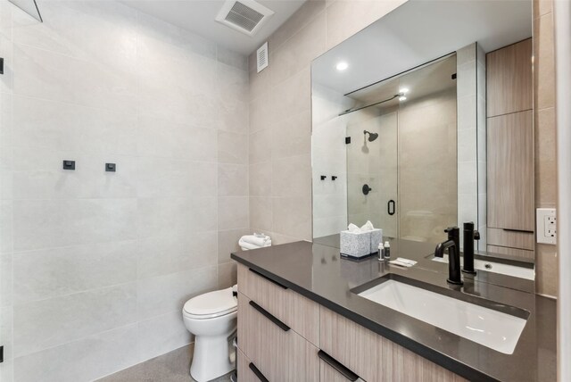 96 River Run Rd Unit A, Keystone, CO 80435 - bathroom with a stall shower, vanity, tile walls, toilet, and visible vents