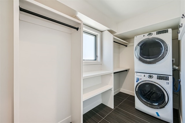 234 Frisco Aly Unit D, Frisco, CO 80443 - laundry room with dark tile patterned floors, stacked washing maching and dryer, baseboards, and laundry area