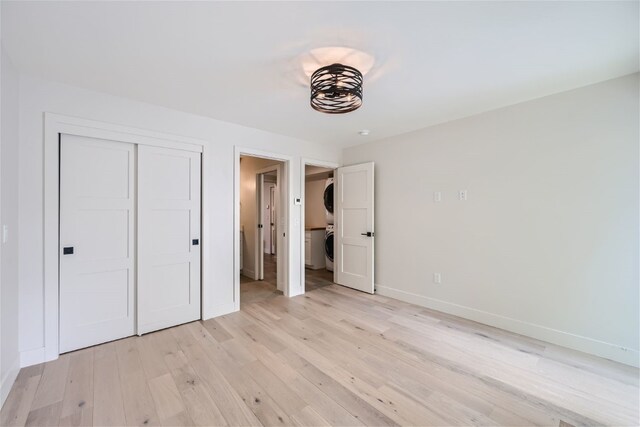 234 Frisco Aly Unit D, Frisco, CO 80443 - unfurnished bedroom with stacked washing maching and dryer, a closet, baseboards, and light wood-type flooring