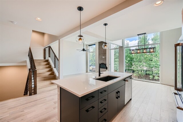 234 Frisco Aly Unit D, Frisco, CO 80443 - kitchen with stainless steel dishwasher, a sink, light wood-type flooring, light countertops, and decorative light fixtures