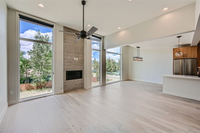 234 Frisco Aly Unit D, Frisco, CO 80443 - unfurnished living room with a fireplace, ceiling fan, light wood-type flooring, and plenty of natural light
