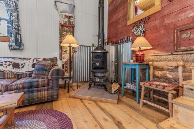 1211 County Road 213, Parshall, CO 80468 - sitting room with wooden walls, a wood stove, and hardwood / wood-style flooring
